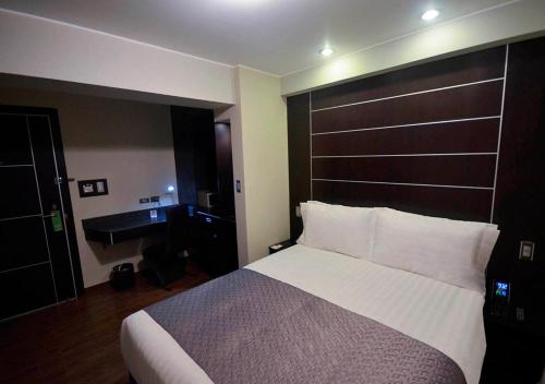 a hotel room with a large bed and a desk at qp Hotels Trujillo in Trujillo