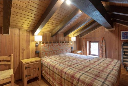1 dormitorio con 1 cama en una habitación de madera en La baita di Brusson, en Brusson