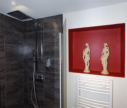 a bathroom with a shower and a red wall at La chenevière in Saint-Rémy-de-Chargnat