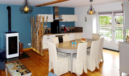 a kitchen and dining room with a table and chairs at La chenevière in Saint-Rémy-de-Chargnat