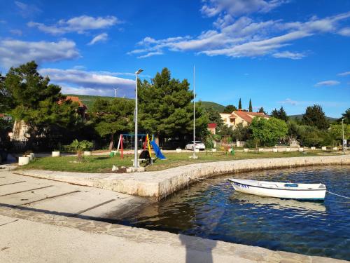 a small boat in the water near a playground at VILLA PUNTA BLAVA - beach front, ideal for kids, large terraces with sea view, internet, Netflix, no pets allowed, 3Kw EV ch in Obrovac