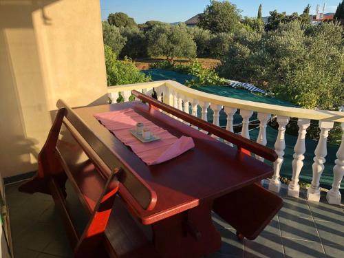 a table on a balcony with a view of a pool at Apartments Marina in Sveti Filip i Jakov