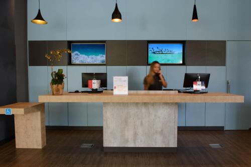 a woman standing at a reception desk in an office at ibis Itatiba in Itatiba