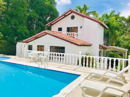 a villa with a swimming pool and a house at Casa Hacienda La Estancia piscina privada in Melgar