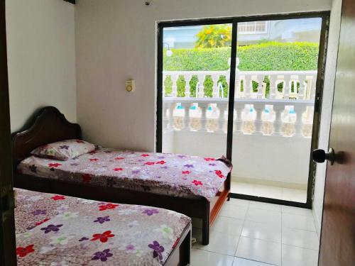 um quarto com duas camas e uma janela com garrafas de água em Casa Hacienda La Estancia piscina privada em Melgar