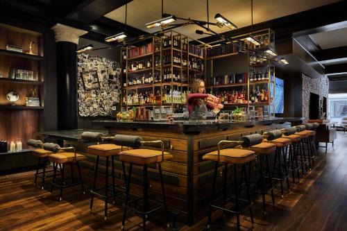 a woman standing at a bar in a restaurant at Hotel Emblem San Francisco in San Francisco