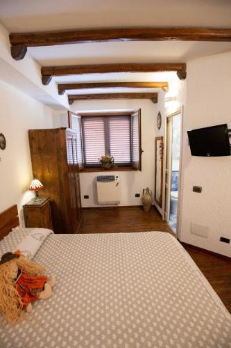 a bedroom with a bed and a tv on a wall at La Casa In Pietra in Santa Caterina Villarmosa