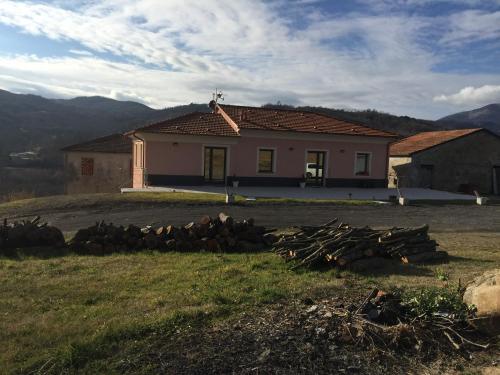 a house with a pile of logs in front of it at Le Pianelle in Varese Ligure