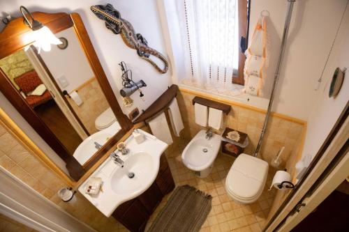 a bathroom with a sink and a toilet and a mirror at La Casa In Pietra in Santa Caterina Villarmosa