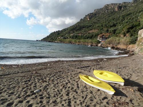 two yellow surfboards on a sandy beach next to the ocean at Endless Blue in Ravdhoúkha