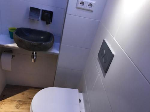 a bathroom with a black sink and a toilet at TU Ferienzimmer in Ulm Stadtmitte in Ulm