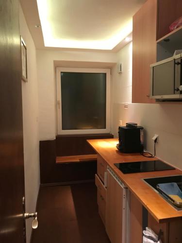 a small kitchen with a large window in a room at TU Ferienzimmer in Ulm Stadtmitte in Ulm