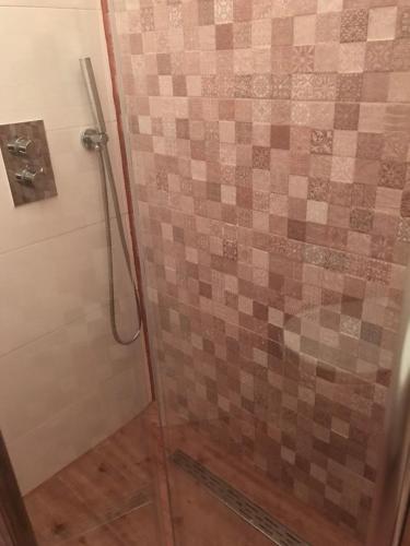 a bathroom with a shower with a tiled wall at TU Ferienzimmer in Ulm Stadtmitte in Ulm
