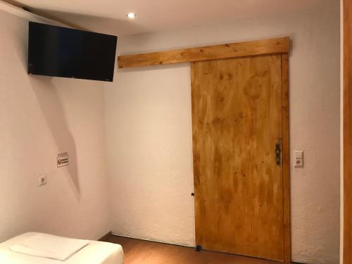 a room with a door and a television on the wall at TU Ferienzimmer in Ulm Stadtmitte in Ulm