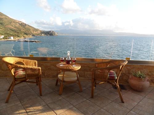 a table and chairs on a balcony overlooking the ocean at Endless Blue in Ravdhoúkha