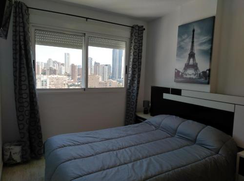 a bedroom with a bed and a window with the eiffel tower at Mediterranean Bliss 317 in Cala de Finestrat