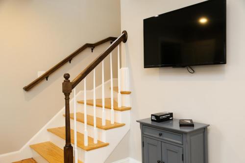 a living room with a staircase with a flat screen tv at Two Bedroom with Lake View in Wolfeboro