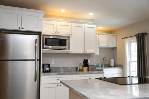 a kitchen with white cabinets and a stainless steel refrigerator at Two Bedroom with Lake View in Wolfeboro