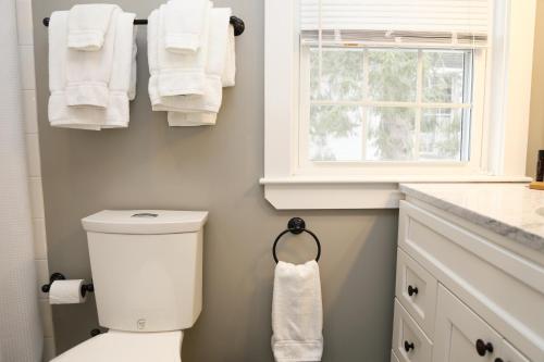 a bathroom with a toilet and a window and towels at Two Bedroom with Lake View in Wolfeboro