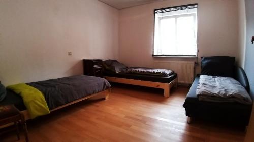 um quarto com duas camas e um sofá e uma janela em Fewo Fischer em Göppingen