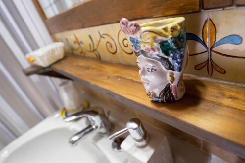 a cup sitting on a counter next to a sink at La Casa In Pietra in Santa Caterina Villarmosa