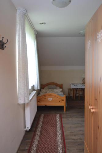 a bedroom with a bed and a window and a rug at Pokoje Gościnne u Joli in Szczyrk
