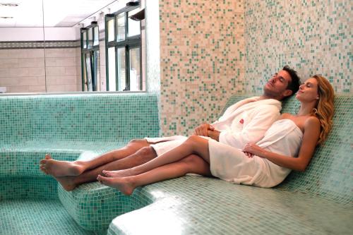 a man and a woman laying in a bath tub at Parc Hotel Gritti in Bardolino