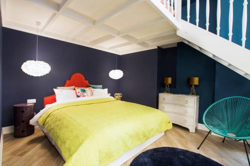 1 dormitorio con cama amarilla y pared azul en Art Apartment en Cracovia