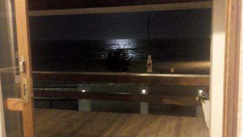 a room with a view of the ocean at night at Pousada Beira Mar - Suítes Frente ao mar in Torres
