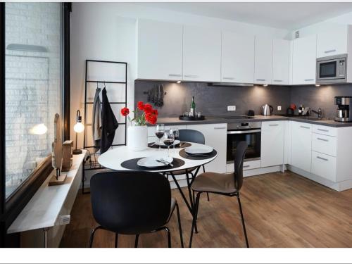 a kitchen with a table and chairs and white cabinets at Grünstrand in Travemünde