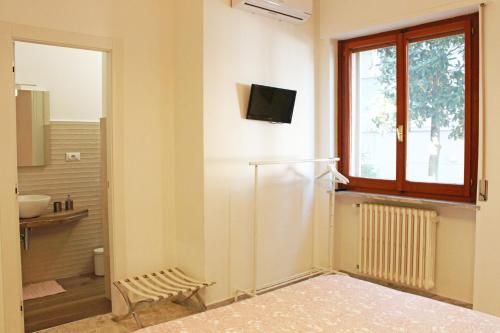 a bathroom with a refrigerator and a television on the wall at I Tre Cardilli in Matera