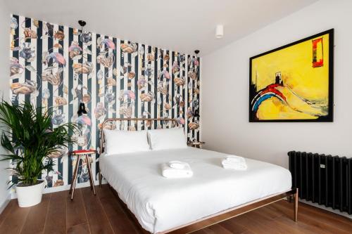 ein Schlafzimmer mit einem Bett und einem Wandgemälde in der Unterkunft Crashpads Shoreditch the Club Row Collection in London