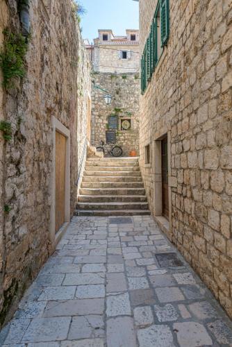 an alley with stairs in an old stone building at Apartments Villa Tudor in Hvar
