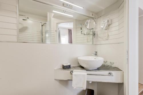 a white bathroom with a sink and a mirror at Apartments Villa Tudor in Hvar