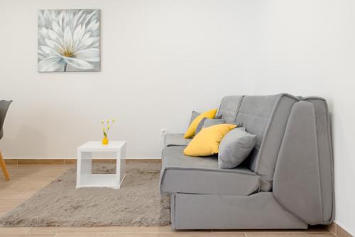 a grey couch with yellow pillows in a living room at Apartments Villa Tudor in Hvar
