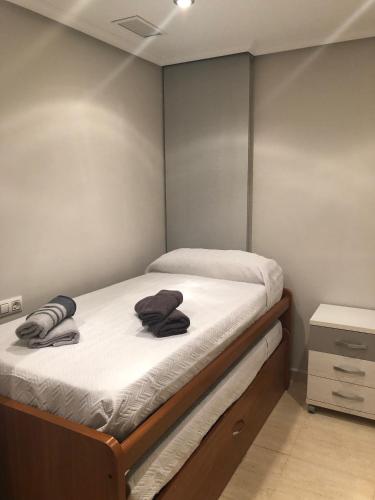 a small bedroom with a bed with towels on it at Piso Soballa, Centro y Playa in Santa Pola