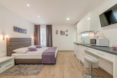 a hotel room with a bed and a kitchen at Apartments Villa Tudor in Hvar