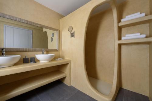 a bathroom with two sinks and a mirror at Elitoz Suites in Oia