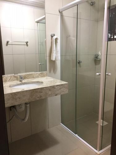 a bathroom with a sink and a glass shower at Hotel Morada dos Pinheiros in Bom Jardim da Serra