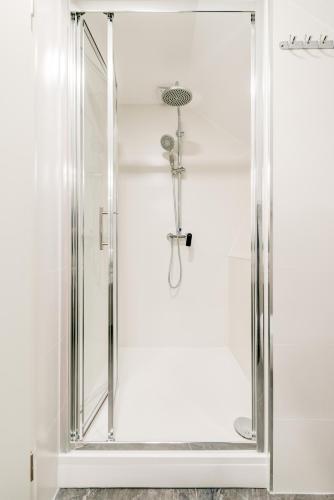 a shower with a glass door in a bathroom at Apartments Villa Tudor in Hvar