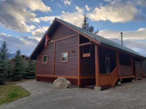 a large wooden cabin with a rock in front of it at Cedar House Restaurant & Chalets in Golden