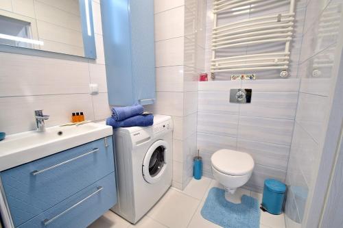 a bathroom with a washing machine and a sink at Apartament Lazurowa Przystań Amber Sand w Kołobrzegu in Kołobrzeg
