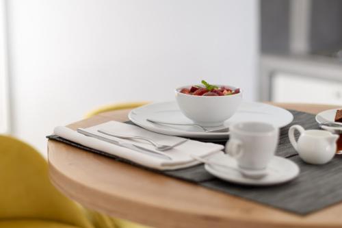 a table with a bowl of fruit and a cup of coffee at Elitoz Suites in Oia