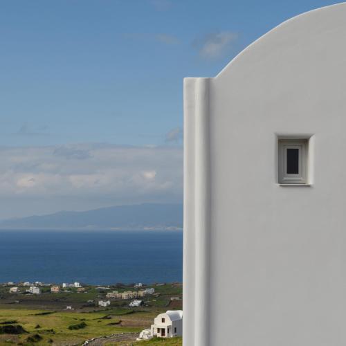 a white building with a window on the side of it at Elitoz Suites in Oia
