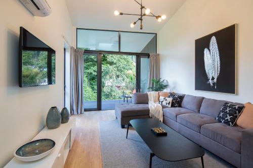 a living room with a couch and a table at Koura Apartments Central Queenstown in Queenstown