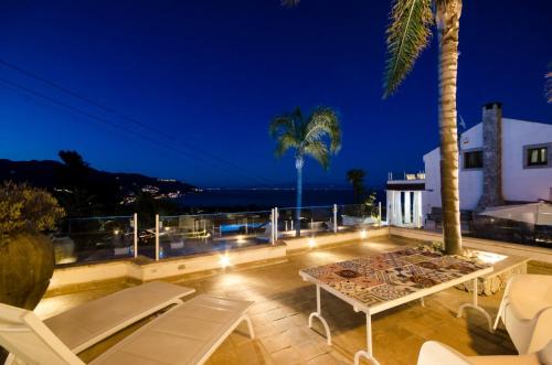 a villa with a view of the ocean at night at Villa Zagara Garden Spectacular Sea View in Taormina in Taormina
