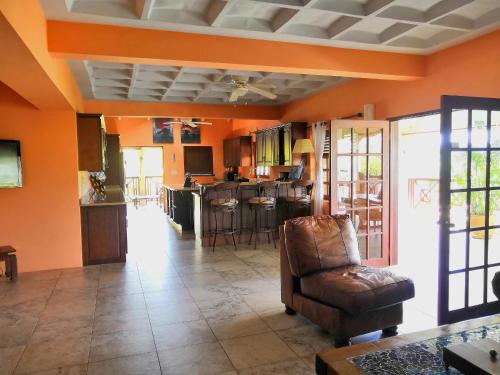 a living room with orange walls and a chair at Villa Touloulou in English Harbour Town