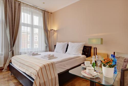 カトヴィツェにあるJagiellońska 3 ApartHotelのベッドとテーブルが備わるホテルルームです。