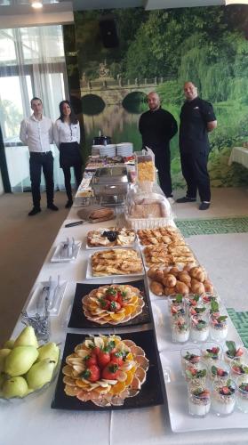 a long buffet of food on a table with people at RAYA Garden - Park Hotel & Winery in Veliko Tŭrnovo