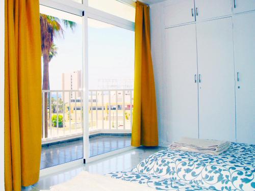 プラヤ・デ・ラス・アメリカスにあるApartment in Torres de Yomely Complexのベッドルーム1室(ベッド1台、大きな窓付)